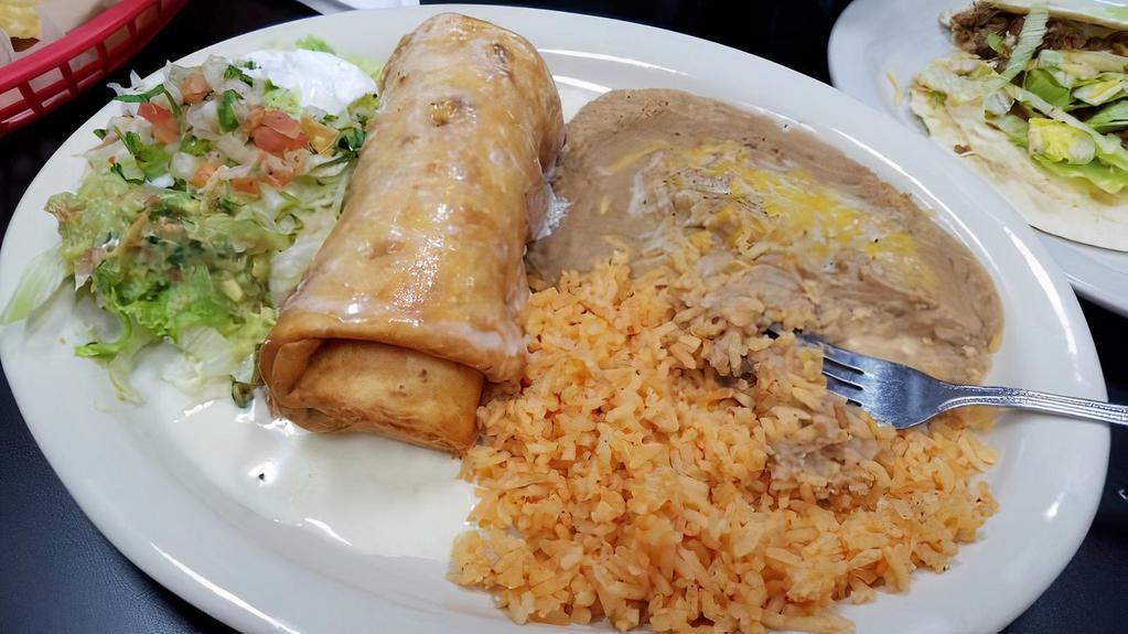 Chimichanga, Mexican Rice & Beans · A flour tortilla stuffed with your choice of steak chunks or chicken, then deep-fried to a golden brown. Topped with cheese sauce and served with rice beans.