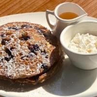 Oat Milk Blueberry Pancakes · Pistachios, almond-coconut whipped cream, powdered sugar, agave.