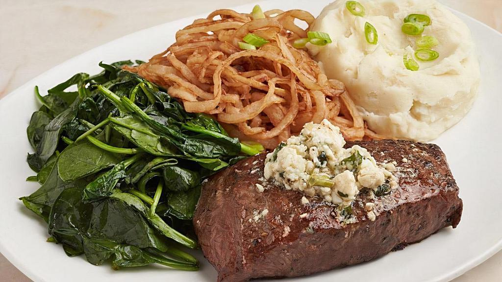 Local Flat Iron Steak · Topped with Firefly Farms bleu cheese butter and crispy onion straws, mashed potatoes, scallions, and sauteed garlic spinach.