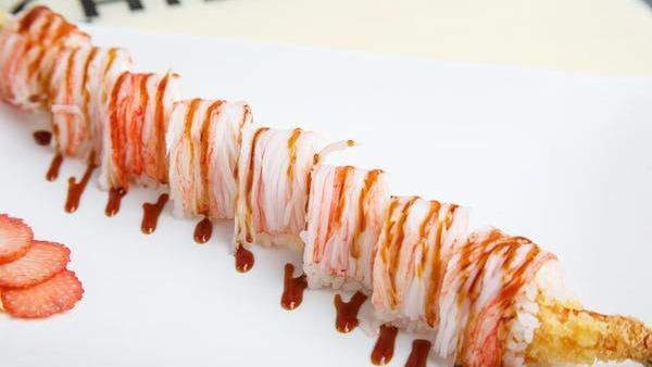 Dancing Roll · Shrimp tempura, cream cheese, and avocado. Wrapped in soy paper and topped with fresh crab meat and eel sauce. No substitutions.