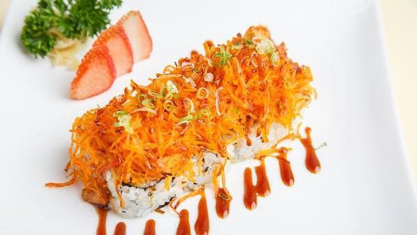 Dynamite Roll · Crab meat, cucumber, and avocado topped with baked fish, masago, scallions, mayo, and special sauce.