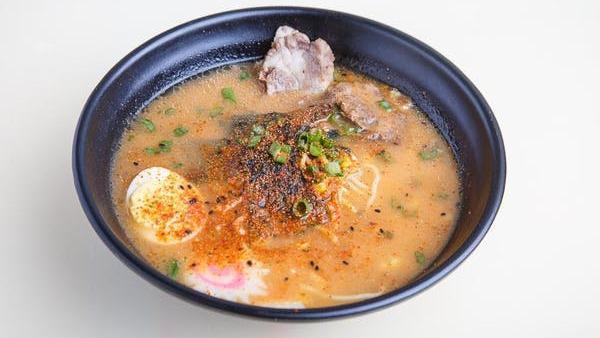 Spicy Tonkotsu Ramen · Spicy. Thick, red broth simmered with pork belly and bones. Served with traditional curly ramen noodles and topped with beef bbq, fish cake, egg, corn, and green onions.