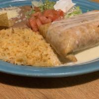 Chimichanga · Chimichanga topped with Queso, Lettuce, Tomato, Sour Cream.  Served with rice and beans