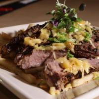 Steak Pomme Frites · 10 oz NY strip topped with shaved smoked gouda and scallions over fries smothered in hunter'...