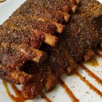 1/2 Rack Of Ribs · 1/2 rack of ribs slowly smoked and seasoned with our house made rub, sauce served on the sid...