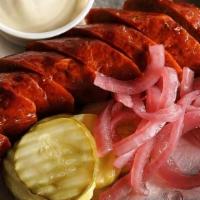 Our Smoked Sausage · Smoked, House Recipe Sausage Link Served with Pickles, Pickled Red Onions, and Smoked Mustar...