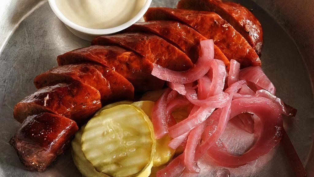 Our Smoked Sausage · Smoked, House Recipe Sausage Link Served with Pickles, Pickled Red Onions, and Smoked Mustard Dressing.