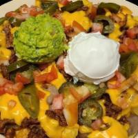 Nachos · chips topped with the meat of your choice, jalapeños, beans, yellow cheese, tomatoes, guacam...
