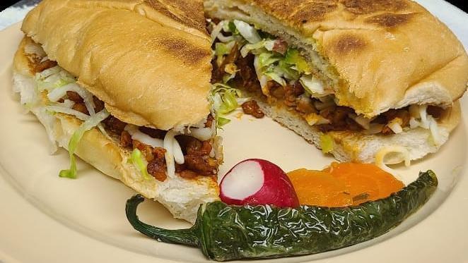 Torta · Beans, meat, onions, cilantro, cheese, lettuce, tomatoes, avocado, and mayo