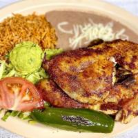 Pollo Asado · half of a grilled chicken with a side of rice, beans, salad and tortillas