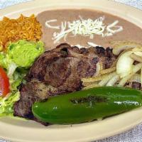Carne Asada · two pieces of steak cooked on charbroilers (parrilla) with a side of rice, beans, salad and ...