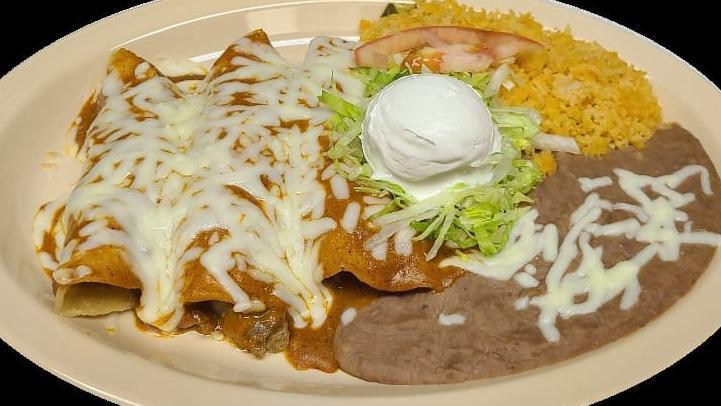 Enchiladas · corn tortilla stuffed with the meat of your choice covered in special sauce and melted cheese and a side of rice and beans along with lettuce, sour cream and tomatoes.