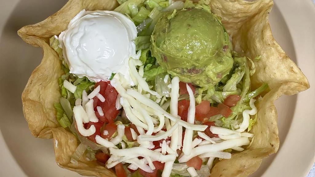 Taco Salad · beans, meat of your choice, guacamole, sour cream, tomatoes, cheese, and  lettuce all in a flour tortilla plate.