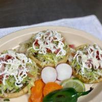 Sopes · homemade tortilla with meat, beans, onions, cilantro, cheese, sour cream, tomatoes, parmesan...