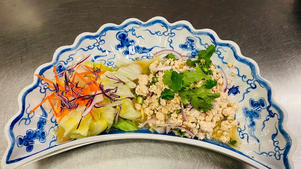 Larb Gai · Spicy chicken salad, Larb Gai is made with minced chicken tossed with lime juice, red onion, chili powder, and spring onion and topped with mint. Cooked medium spicy.