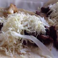 Tacos De Carne Asada · Three marinated grilled steak tacos topped with sauteed onions,cilantro,cabbage and cheese,s...