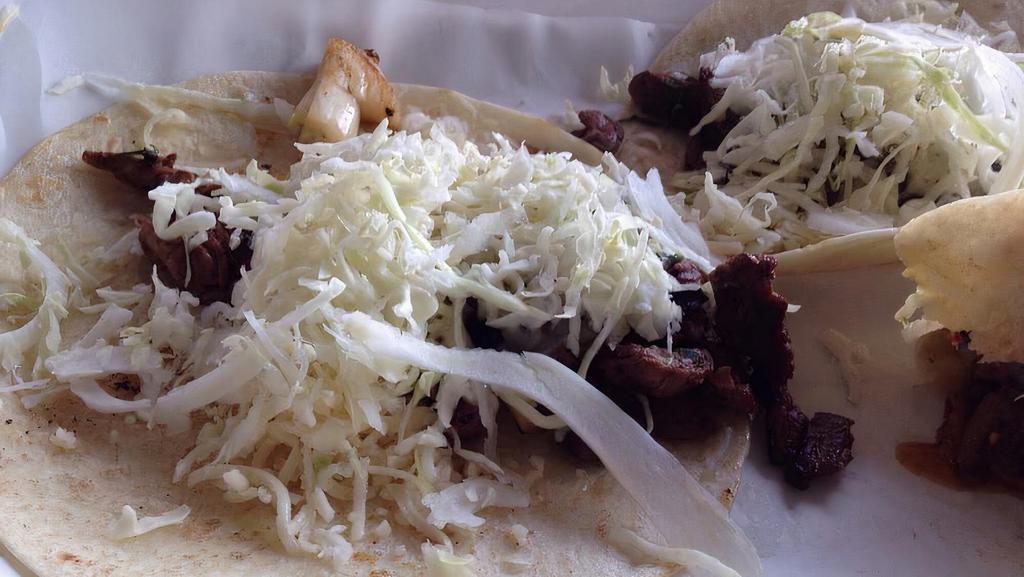 Tacos De Carne Asada · Three marinated grilled steak tacos topped with sauteed onions,cilantro,cabbage and cheese,served with homemade hot salsa.