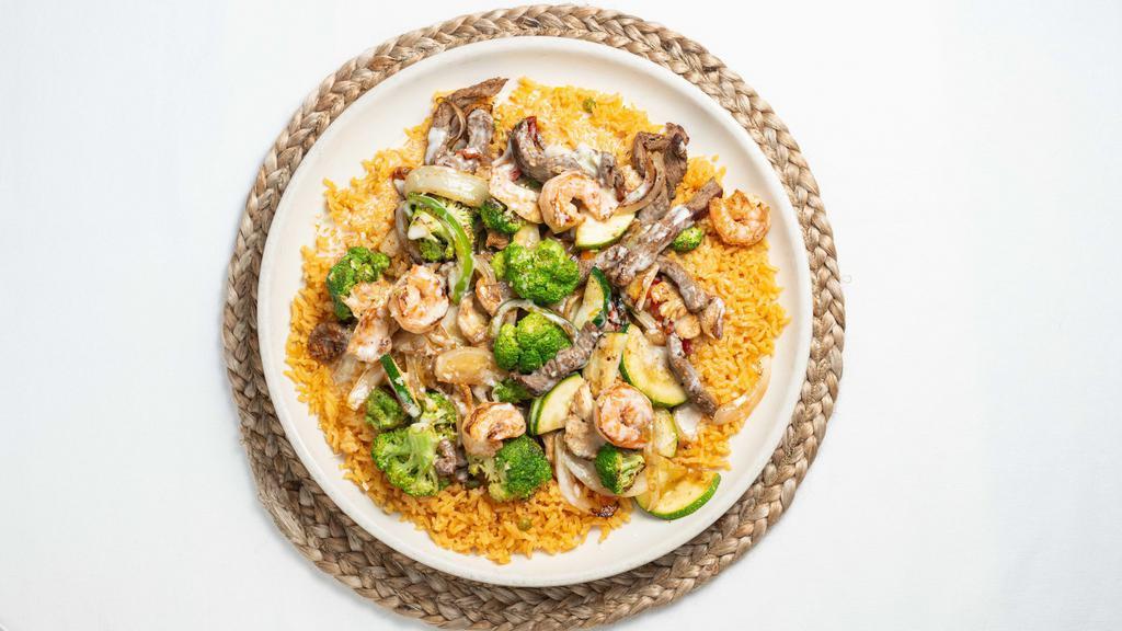 Peluza  · Steak, shrimp, chicken broccoli, onions, bell peppers and zucchini on a bed of rice topped with queso sauce.