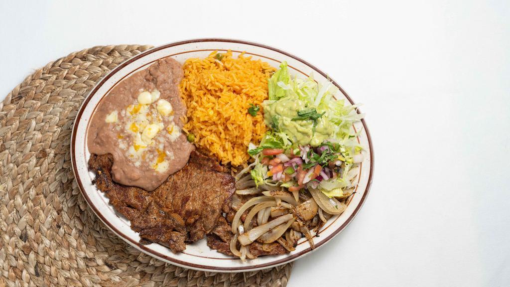 Carne Asada · Thinly sliced ribeye steak with grilled onions. Served with rice, beans, tortillas, and guacamole salad.