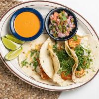 Shrimp Tacos · Three soft tacos filled with seasoned shrimp. Topped with onions, cilantro. Served with spic...