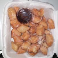 Zapollis · Fried pieces of dough with powdered sugar.