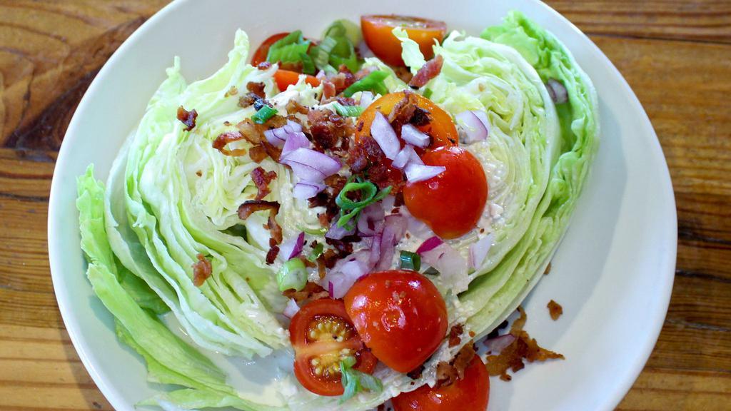 Iceberg Wedge · Tomatoes, onions, bacon, blue cheese crumbles, blue cheese dressing