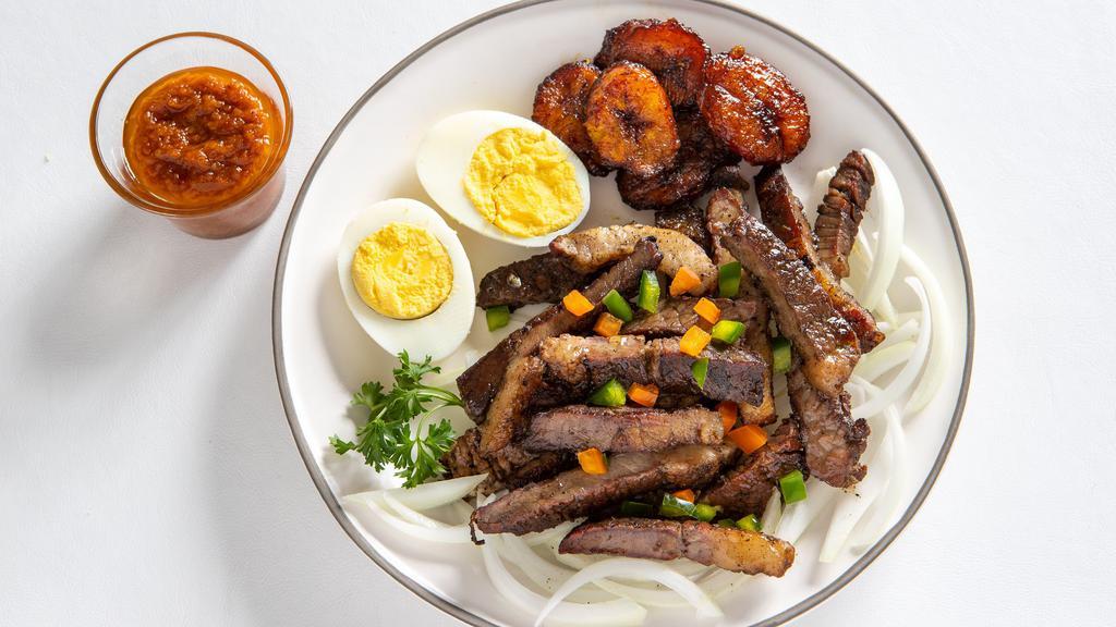 Suya (Grilled Beef) · Grilled beef served with onions grilled or raw, sweet plantains, eggs, and spicy homemade sauce.