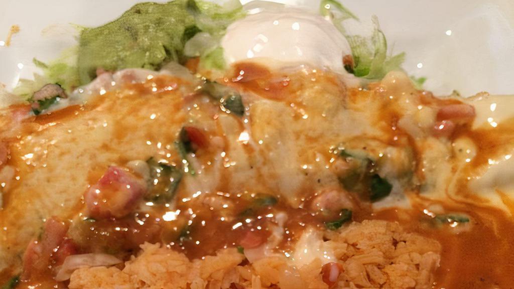 Super Burrito · choice of steak or grilled chicken stuffed with onions, bell peppers, tomatoes, cheese and beans, covered with our special salsa, topped with lettuce, guacamole, sour cream and pico de gallo. Served with rice.