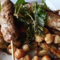 Lamb Satay · Grilled lamb satay over roasted chickpeas, brussel sprouts & candied bacon.
