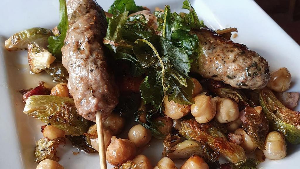 Lamb Satay · Grilled lamb satay over roasted chickpeas, brussel sprouts & candied bacon.