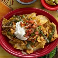 Nachos Tapatios · Nachos topped with fajita meat, bell peppers, cheese, and onions. Served with Pico de Gallo,...