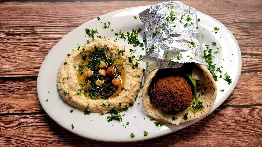 Falafel Pita · Vegetarian. Vegetarian patties, a blend of chicken peas, vegetables, and seasonings over lettuce, tomato and tahini sauce. Served with your choice of (1) side.