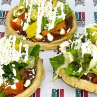 Sopes (3) · Refried beans, lettuce, tomato, cheese & sour cream.