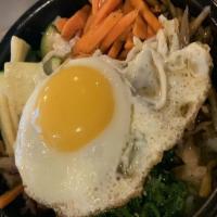 Bibimbap · Bowl of rice topped with an array of individually prepared vegetables and meat and served wi...