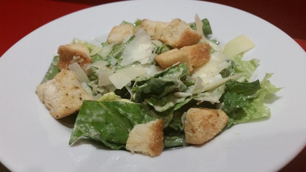 Caesar Salad · Crisp romaine tossed with Caesar dressing & topped with shaved parmesan and house made Asiago croutons.