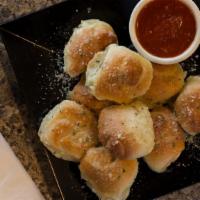 Garlic Knots · These knots are made from scratch daily and baked on the bricks in our oven. Then we toss th...