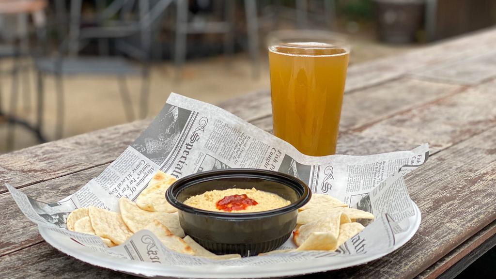 Roasted Garlic Hummus · Thick, smooth, and delicious. Garbanzo beans, fresh roasted garlic, tahini, and lemon juice blended together and topped with olive oil, and sambal oelek for extra spice. Served with pita chips.