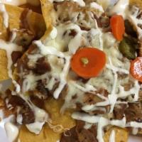 Mexico Nachos · Chicken and Chorizo, cheese, beans, and jalapeno peppers.