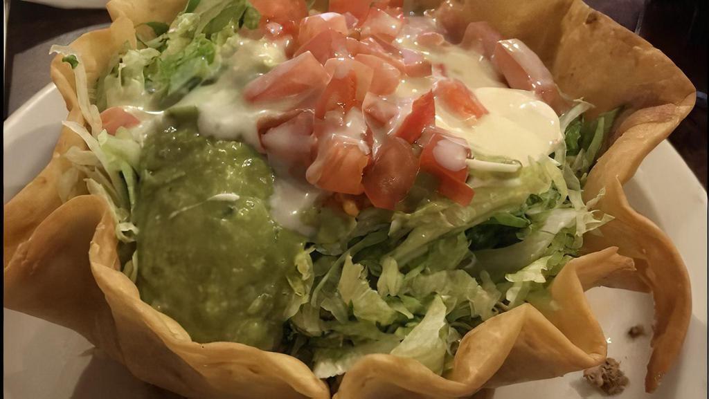 Taco Salad · Ground beef or shredded chicken in a crispy tortilla bowl topped with lettuce, sour cream, guacamole, Pico de Gallo,, and shredded cheese.