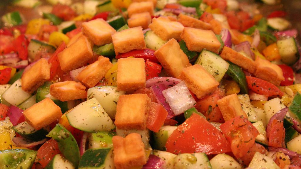 Fattoush · Vegan. Gluten-free (without pita chips). Tomato, cucumber, onion, and bell peppers in a garlic herb vinaigrette.