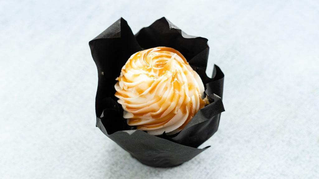Chocolate Caramel Cheesecake · Chocolate fudge cupcake topped with cream cheese buttercream and caramel drizzle.