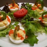 Not Grammas' Deviled Eggs (6 Halves) · Southern recipe garnished with thinly sliced fresh jalapeño and a drizzle of Texas pete.