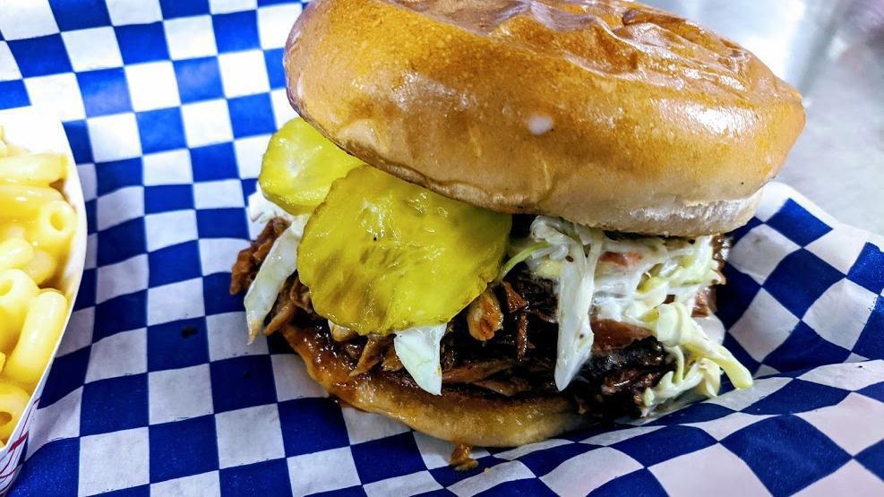 Pulled Rib Meat Sandwich · Pulled rib meat with our sweet sauce and topped with pickles and slaw served on a butter -toasted bun and your choice of one side. Daily supply is limited, we may occasionally run out.