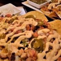 Buffalo Chicken Nachos · House made tortilla chips topped with grilled buffalo chicken, lettuce, beer cheese, blue ch...