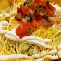 Taco Ensalada · Flour tortilla bowl filled with ground beef or chicken, black beans, lettuce, shredded chees...