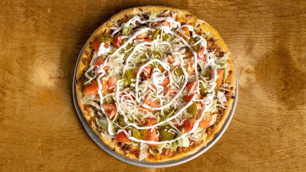 Taco Pizza 11” · Salsa base, baked with seasoned fresh ground beef and onions and topped with chopped lettuce, diced tomatoes, jalapeños, shredded cheese, and sour cream. Too Good!