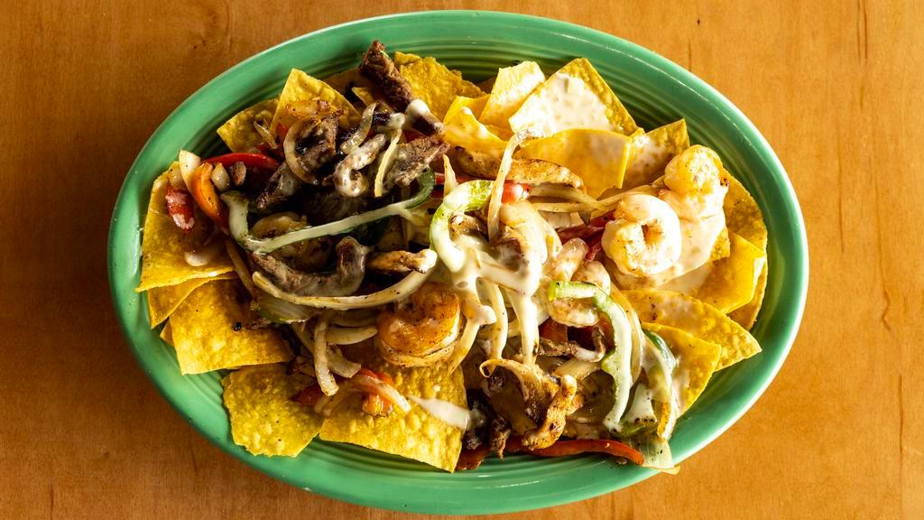 Nacho Fajita Cantina · Tortilla chips prepared with grilled steak, chicken, shrimp, peppers, onions and beans.