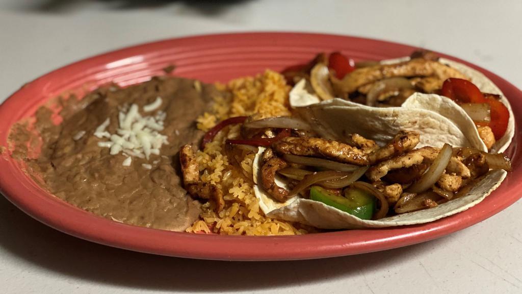 Taco Fajita · Two flour tortillas filled with grilled chicken or steak, grilled peppers and onions served with rice and beans.