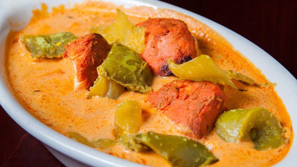 Chicken Tikka Masala · A delicious preparation of tandoori chicken tikka cooked in an almond creamy sauce with onion and green peppers. Comes with a side of rice.