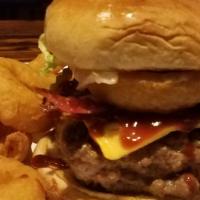Signature Rodeo Burger · 100% seasoned ground beef topped with lettuce cheese tomatoes pickles BBQ sauce and {1} onio...